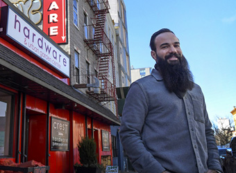 A man is standing outside Crest Hardware, in Williamsburg Brooklyn.