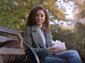 A woman sitting on a park bench.